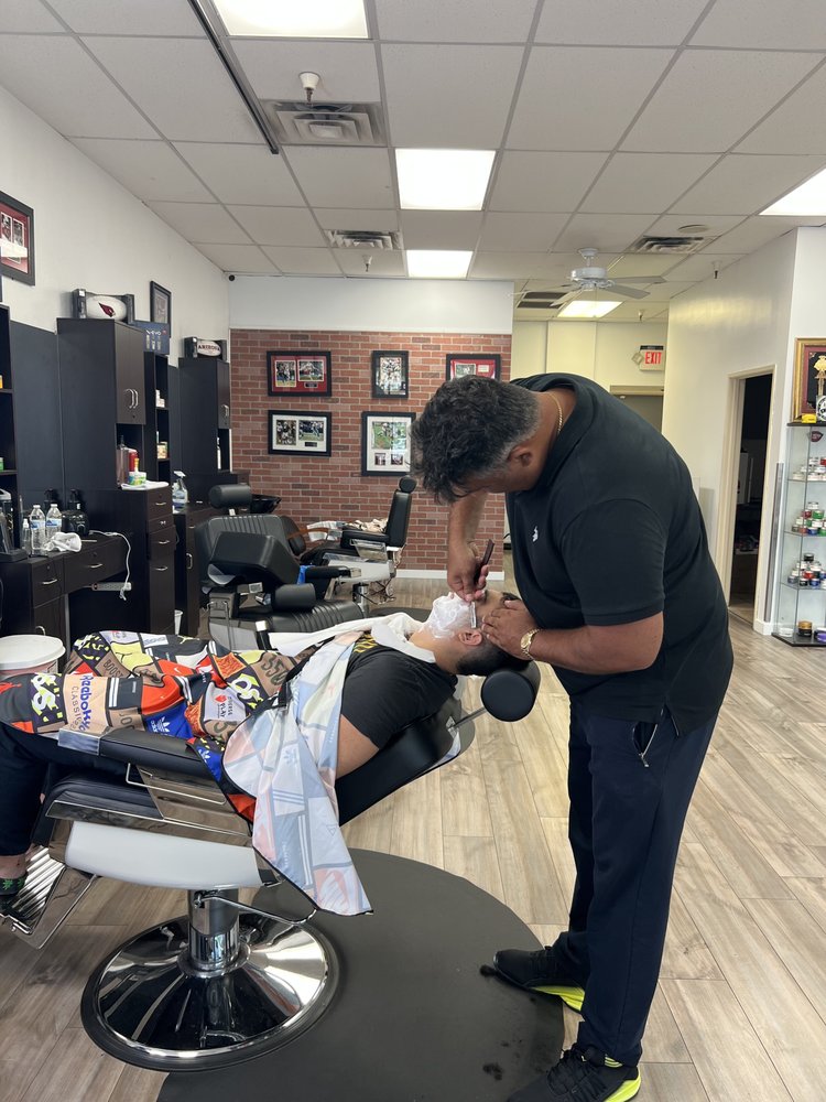 Barber giving a straight razor beard line-up at Next Level Exclusive Barbershop
