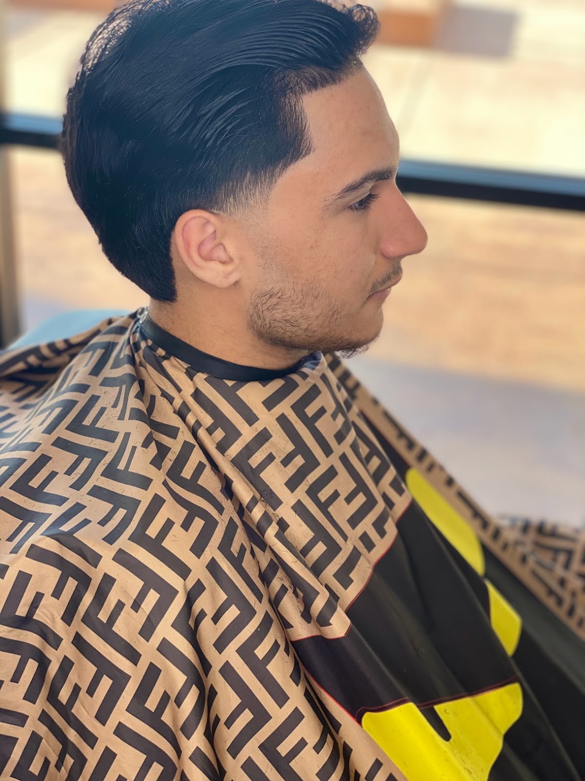 Side-part mullet with a low taper fade and glossy combed finish