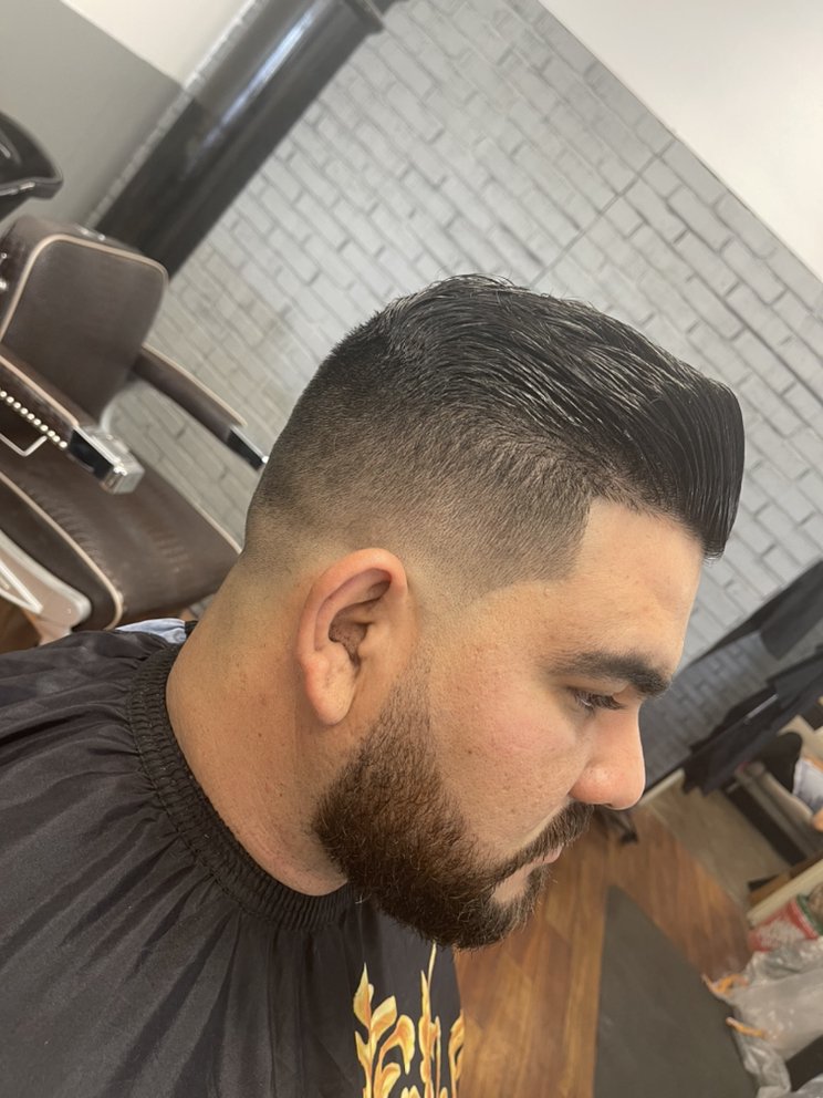 Pompadour with a high skin fade and full beard shaped to the jawline