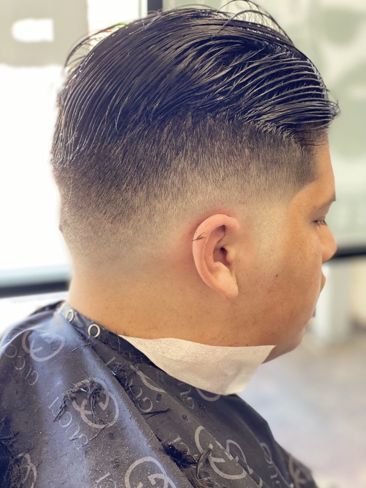 Slick back comb over with a blended skin fade around the ear