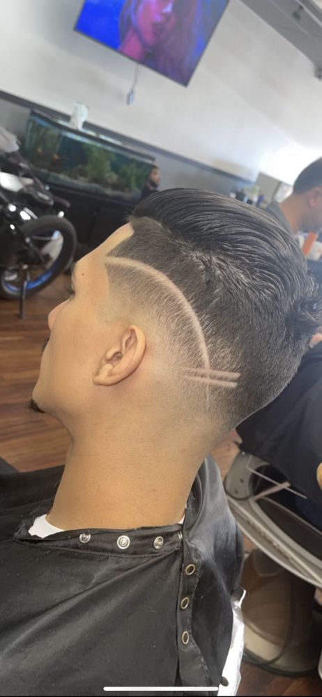 Comb over with a razor-carved double-line hair design in the fade
