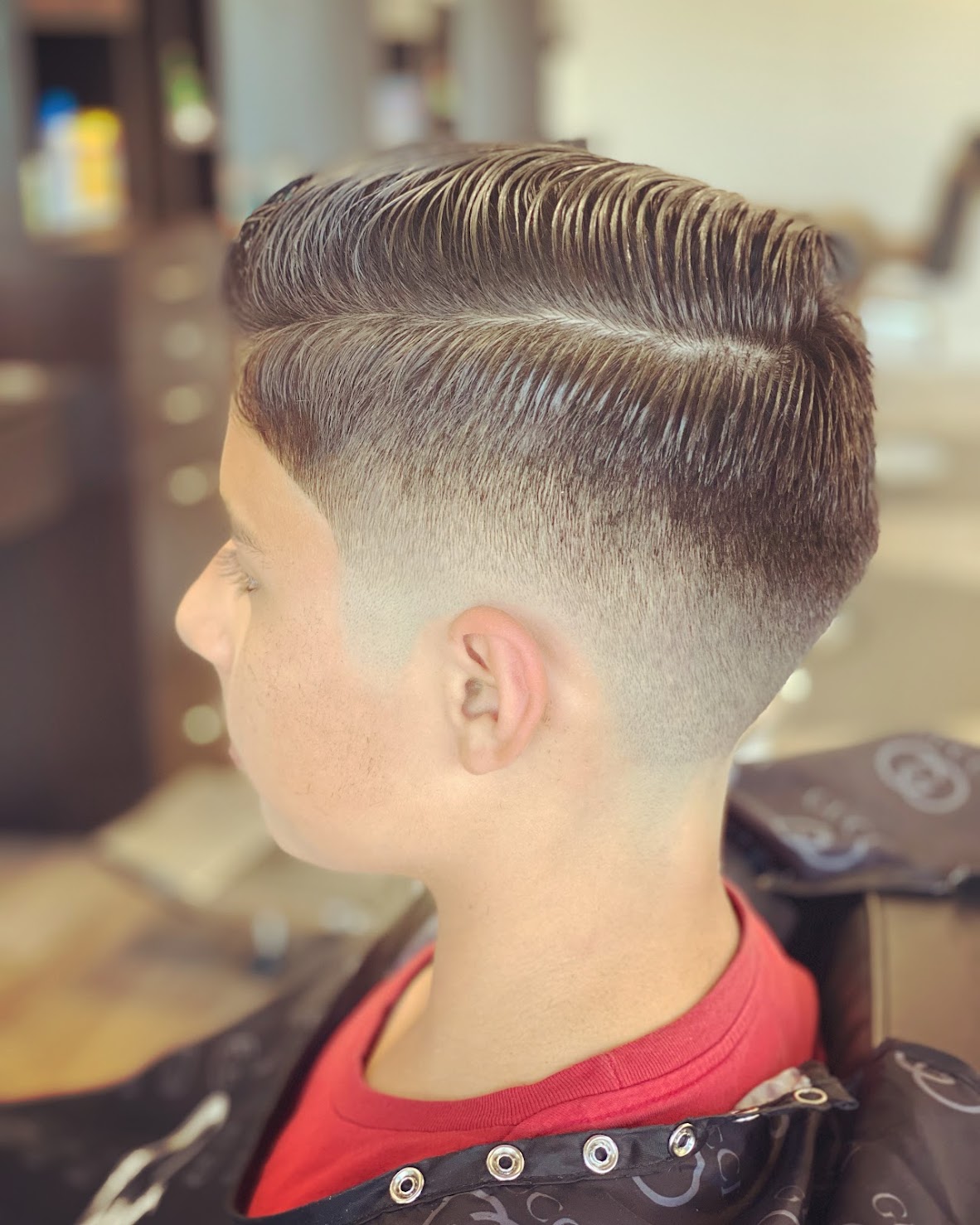 Kids' side part with a sharp taper fade and combed texture on top
